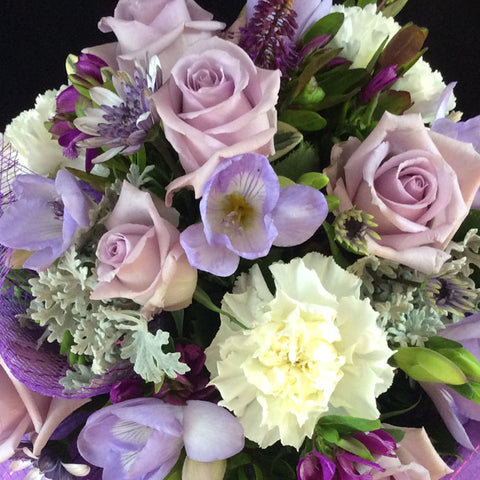 Enjoy this group of mauve roses, freesias and carnations