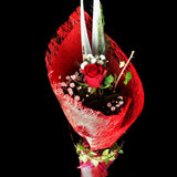 single beautifully wrapped red rose is garnished with greenery and a light spray. Teresa Brough Designer Florist, Takaka NZ