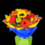 Bring the sunshine indoors with this cheerful Eco-box arrangement of gerbera's, sunflowers and roses to make any one's day a little bit brighter. Teresa Brough Designer Florist. Takaka NZ